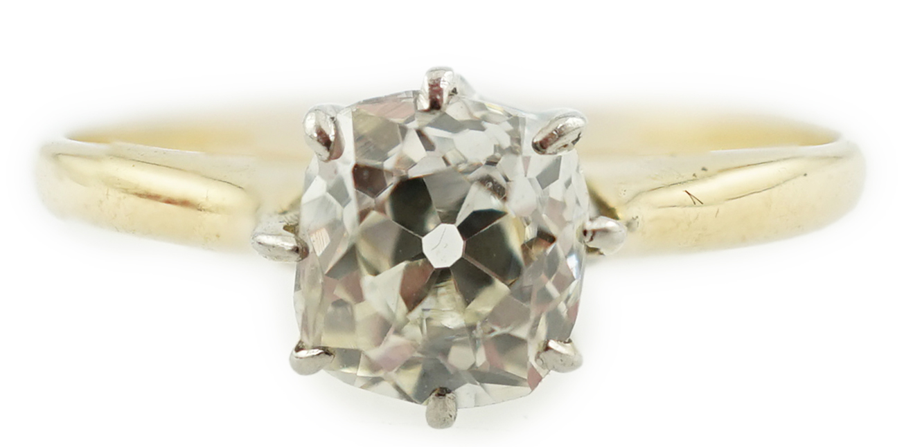 A gold and cushion cut solitaire diamond set ring